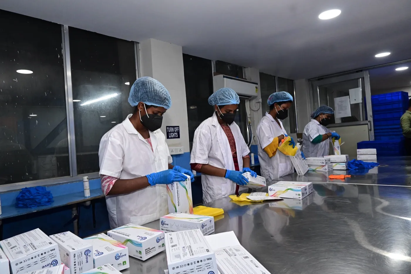 Team member inspecting nitrile gloves before packing